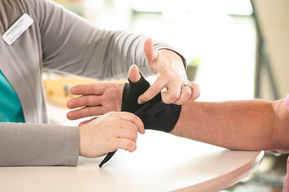 Therapist wrapping a patient's hand