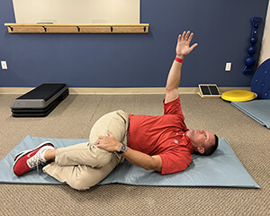 man laying on his side stretching his torso