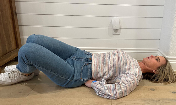 Woman laying on the floor with knees to the side, stretching her lower back.