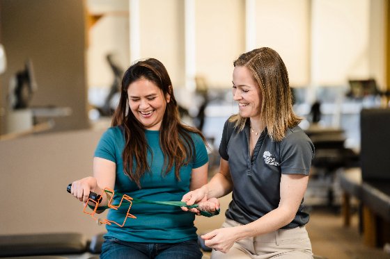 A female physical therapist doing hand exercises with a female patient. 