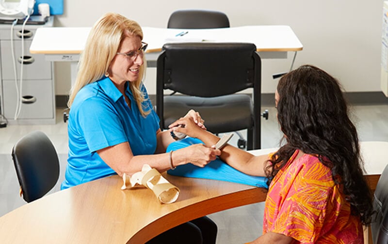 A physical therapist uses a technique called Instrument-assisted soft tissue mobilization to work on patient's forearm muscles